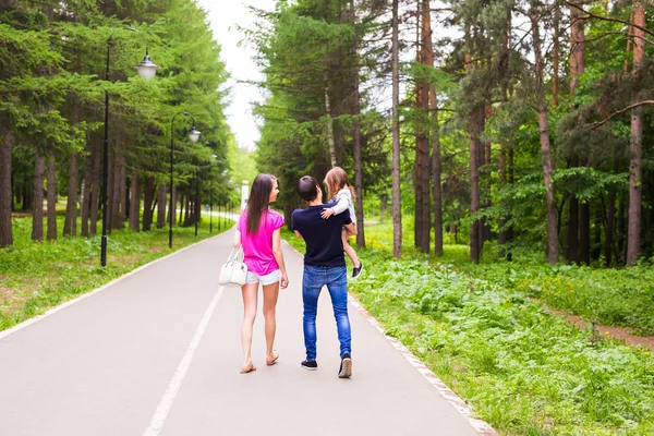 Glückliche junge Familie verbringt Zeit zusammen draußen in der grünen Natur. — Stockfoto