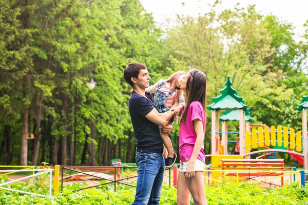 Счастливая мать, отец и дочь в парке — стоковое фото