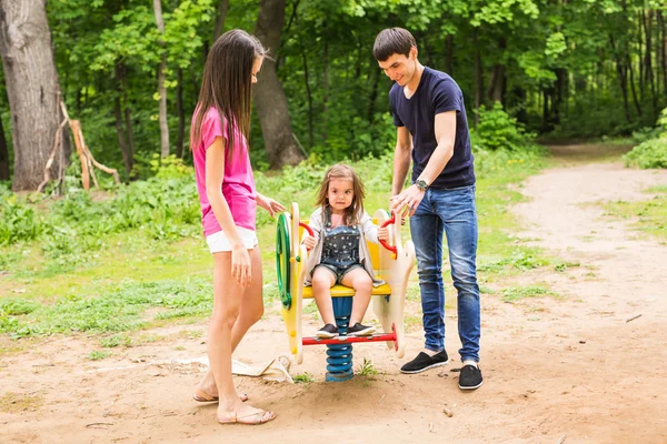 Niña con padres jugando en el parque — Foto de Stock