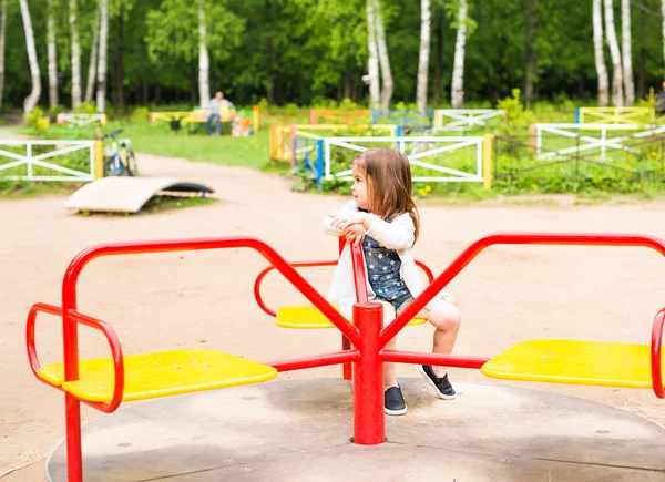 Söta glada lilla flicka rider på merry-go-round — Stockfoto