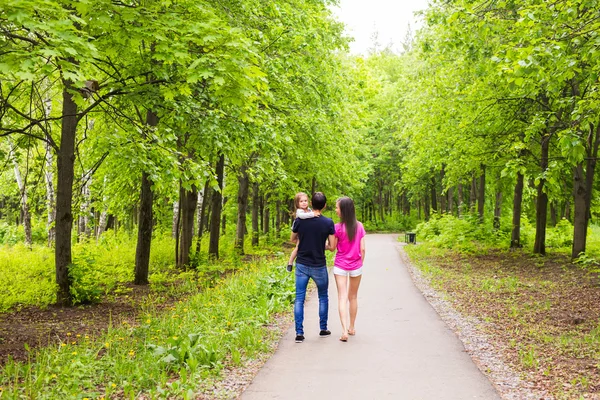 Happy young family walking in green nature. Royalty Free Stock Images