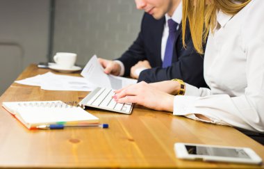 İş adamları başarılı takım çalışmalarının sonuçlarını gösteren çizelge ve grafikleri tartışıyor