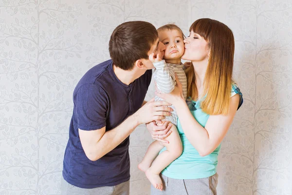 Feliz madre y padre besando a su pequeño hijo — Foto de Stock