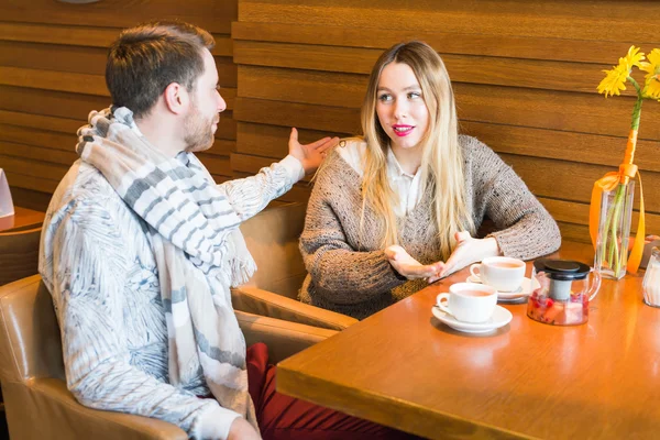 Чоловік розмовляє з жінкою, сидячи в кав'ярні — стокове фото