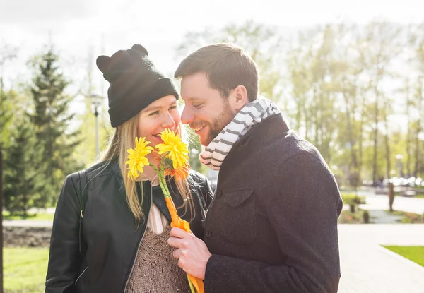 Kärlek, relationer, familj och människor koncept - par med bukett Gerbera i höst park — Stockfoto