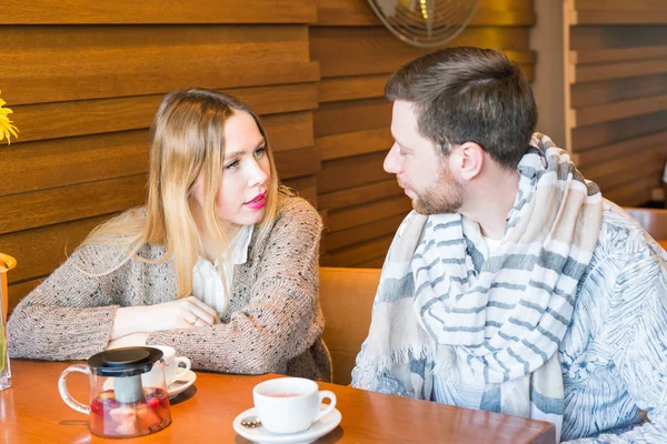 Woman talks with man sitting at the coffee house