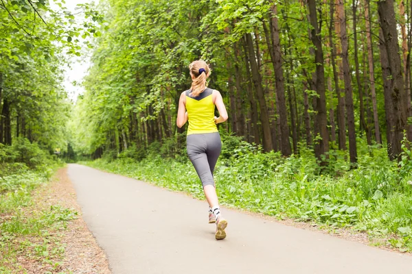 Mujer joven corriendo al aire libre en el parque . — Foto de Stock