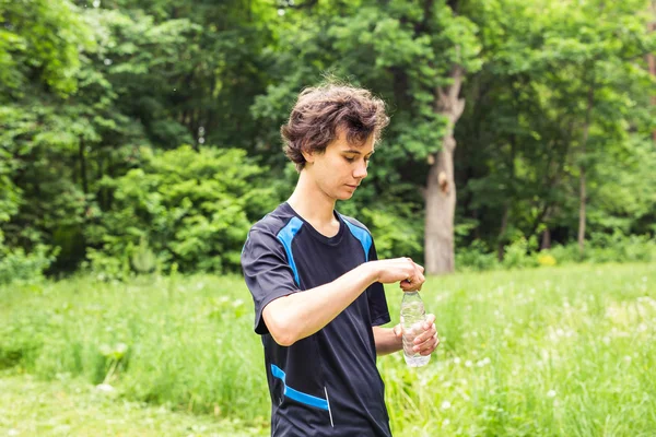 Genç jogger İçmesuyu bahçede zor egzersiz sonrası — Stok fotoğraf