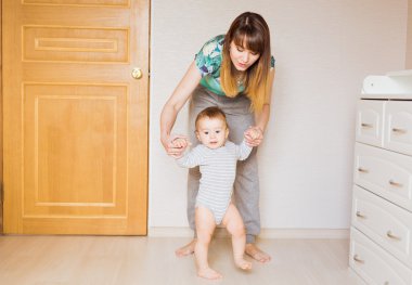 Holding yürümeyi şirin küçük oğlu eller vücut bölüm ilk bebek adım öğretim anne kavramı