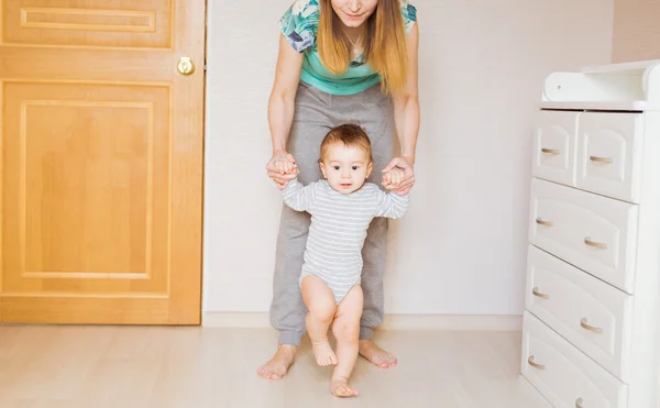 어머니의 도움으로 첫 단계를 복용 하는 아기 — 스톡 사진