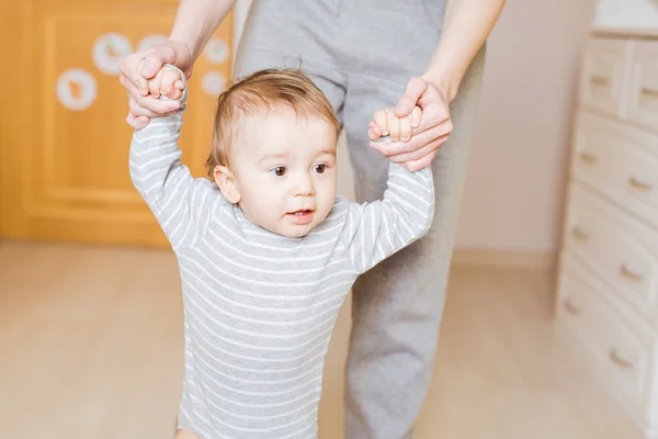 Baby macht erste Schritte mit Hilfe der Mutter — Stockfoto