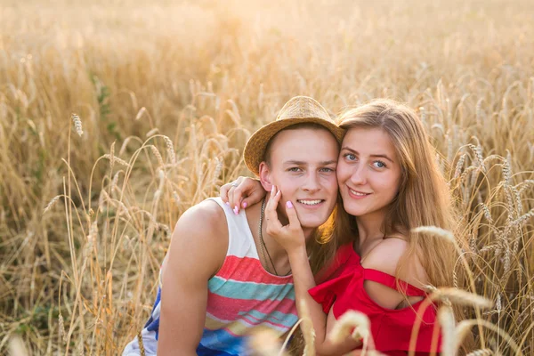 Happy venkovní portrét mladé stylové páru v létě v poli. — Stock fotografie