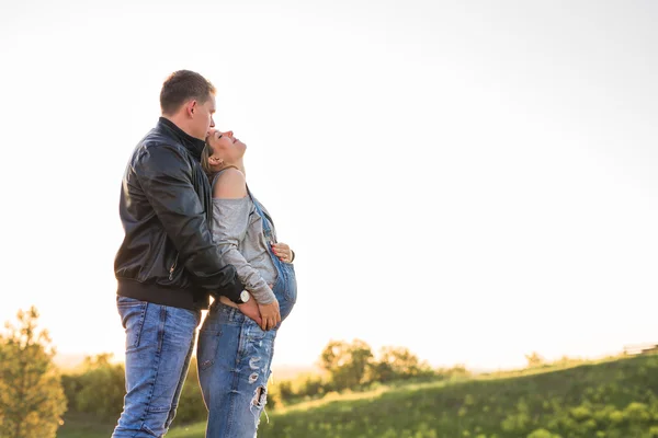 秋の天気を楽しんでいる夫とかわいい妊婦、赤ちゃんを待っている幸せなカップルの愛の概念 — ストック写真