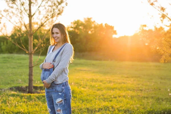 Junge glückliche schwangere Frau entspannt und genießt das Leben in der herbstlichen Natur — Stockfoto