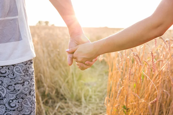 Gros plan de couple aimant tenant la main tout en marchant au coucher du soleil — Photo