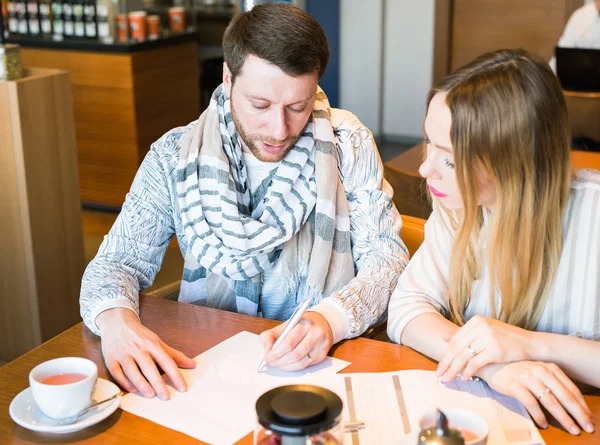 Compañeros de negocios masculinos y femeninos trabajando juntos en un problema difícil en la cafetería interior — Foto de Stock