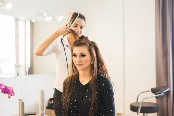 Hairdresser doing haircut for women in hairdressing salon. Concept of fashion and beauty. Positive emotion.