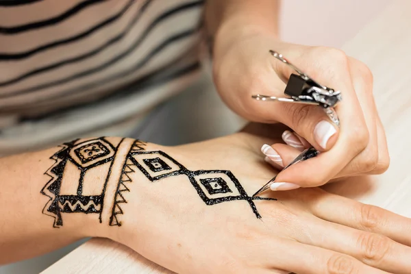 Giovane donna mehendi artista pittura hennè sulla mano — Foto Stock