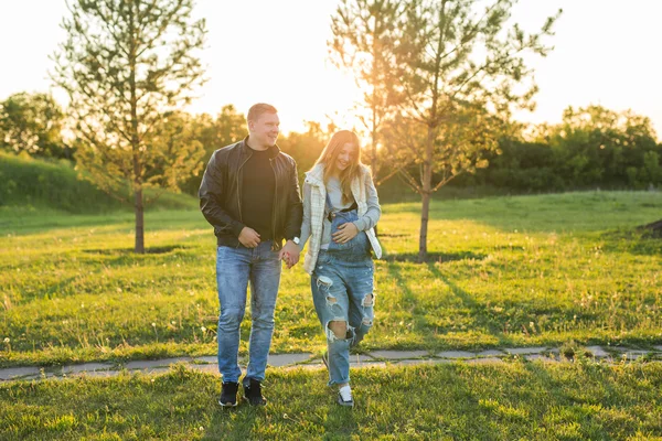 Mulher grávida feliz e seu marido no parque — Fotografia de Stock