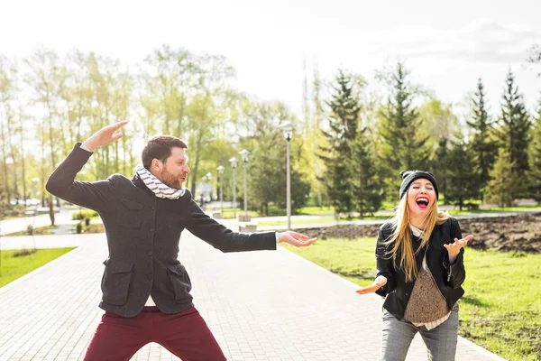 Unga lyckliga par skrattar. Man och kvinna lurar runt i parken — Stockfoto
