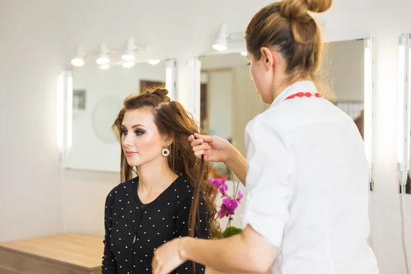 Piękne młode fryzjer podając nową fryzurę kobiece klienta w salonie — Zdjęcie stockowe