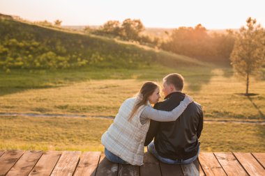 Romantik sonbahar doğada pier üzerine oturan Çift.