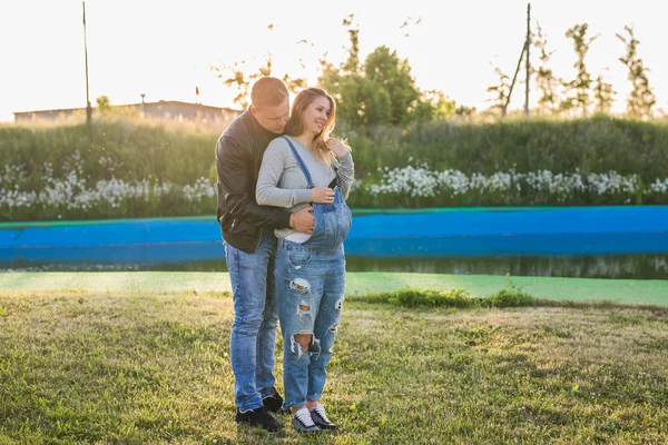 Marido manos en la mujer embarazada vientre, al aire libre —  Fotos de Stock