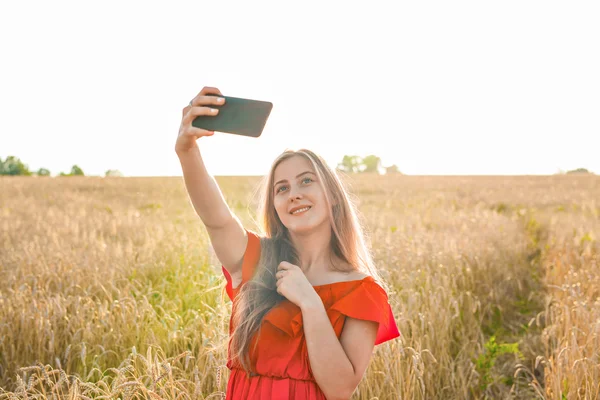 Portrét usměvavé mladé dívky, takže selfie Foto v poli — Stock fotografie