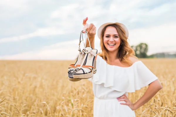 Mujer excitada sosteniendo zapatos nuevos que encontró a la venta — Foto de Stock