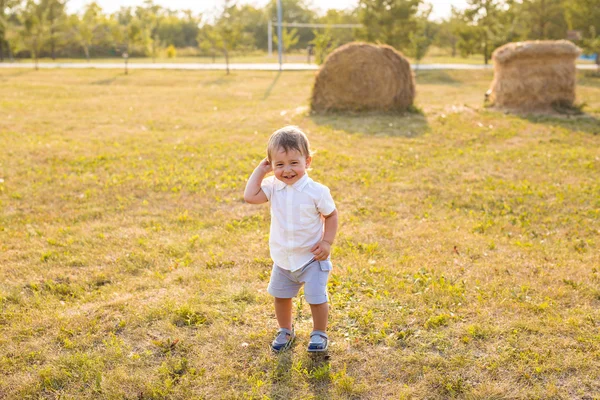 Little boy in the countryside. Toddler playing active games outdoors. Childhood, carefree, childrens games, boy, fresh air, active childrens rest. The concept of childhood. — Stock Photo, Image