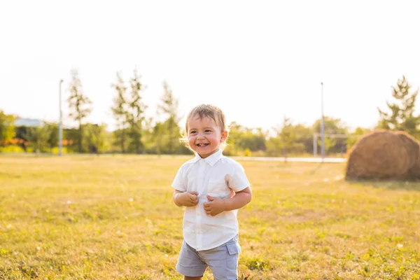 Little boy in the countryside. Toddler playing active games outdoors. Childhood, carefree, childrens games, boy, fresh air, active childrens rest. The concept of childhood. — Stock Photo, Image