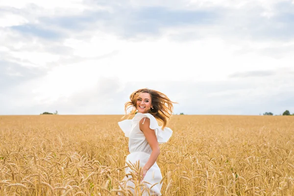 Mulher feliz pulando no trigo dourado — Fotografia de Stock