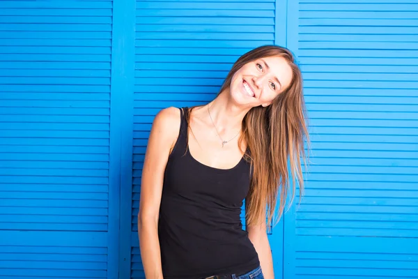 Portret van leuke moderne meisje op een blauwe achtergrond — Stockfoto
