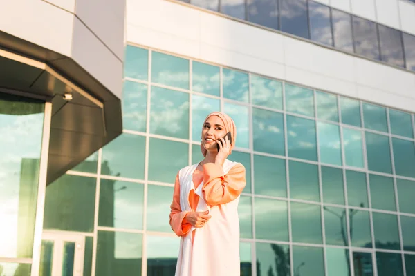 Genç güzel Müslüman kız hijab ve cep telefonu — Stok fotoğraf