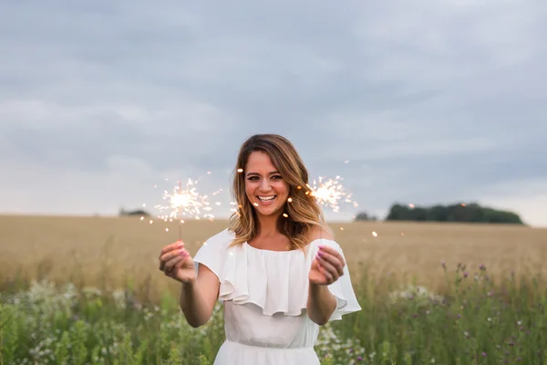 Lächelnde Frau hält Wunderkerze und feiert — Stockfoto