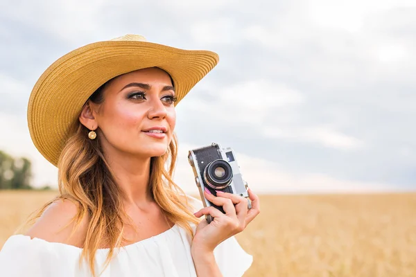 Vrouwelijke fotograaf in het veld met een camera fotograferen — Stockfoto