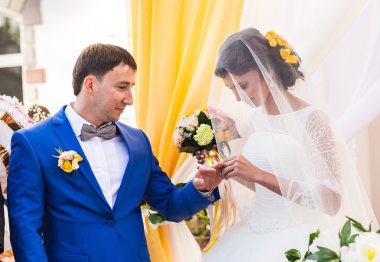 Lüks açık hava düğün töreni üzerinde şık mutlu gülümseyen yeni evliler