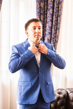 Adam mavi elbiseli onun papyon ayna karşı dururken ayarlama