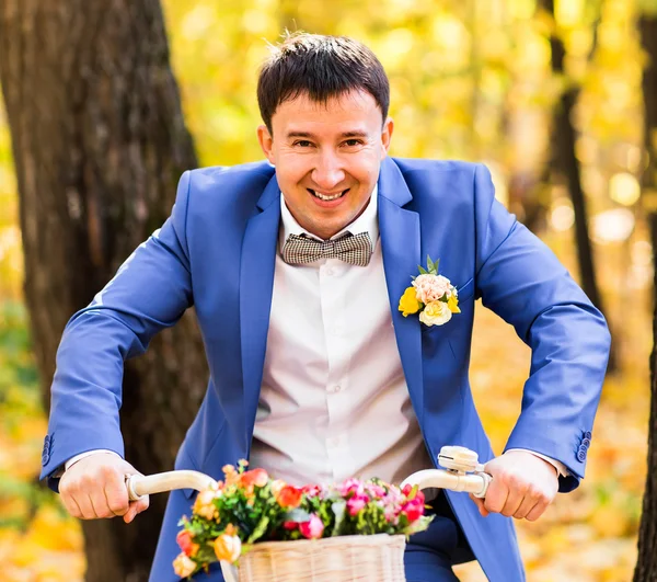 Όμορφος groom και Vintage ποδήλατο με λουλούδια για φθινοπωρινό τοπίο φόντου — Φωτογραφία Αρχείου