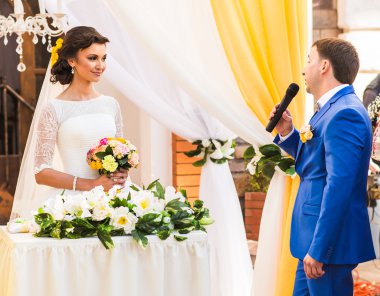 Lüks açık hava düğün töreni üzerinde şık mutlu gülümseyen yeni evliler