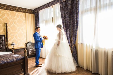 Mutlu lüks gelin ve damat pencerede zengin ışık odada