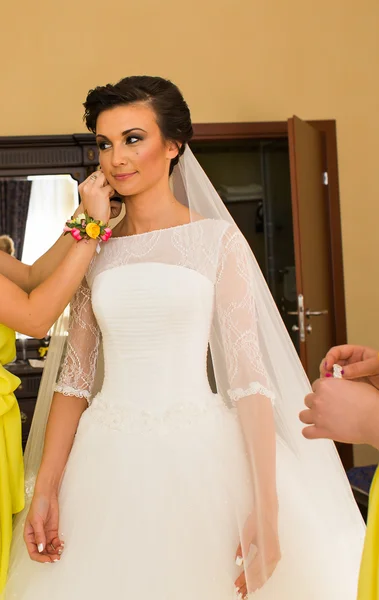 Schöne junge Braut mit Make-up und Frisur im Schlafzimmer, frisch vermählte Frau letzte Vorbereitungen für die Hochzeit. — Stockfoto