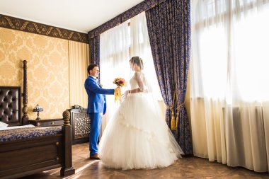 Mutlu lüks gelin ve damat pencerede zengin ışık odada