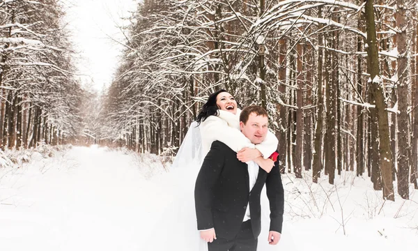 Sposo che dà cavalcata alla sposa nei boschi invernali — Foto Stock