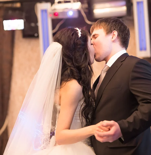Noiva e noivo beijando em seu dia de casamento dentro de casa — Fotografia de Stock