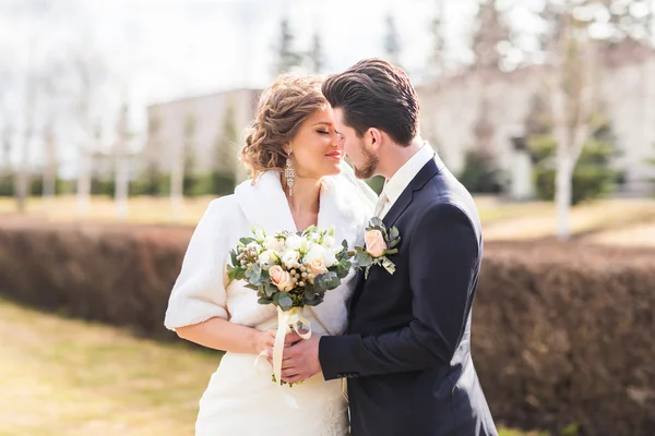 Recém-casados no parque de outono, o noivo abraçando sua noiva . — Fotografia de Stock