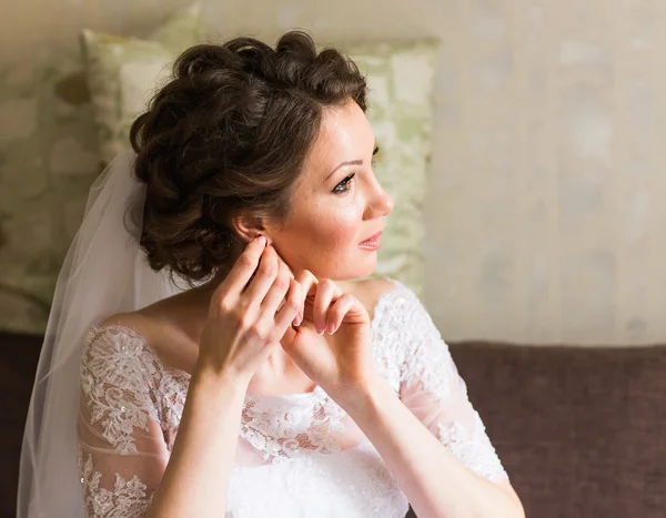 Noiva elegante vestindo brincos, se preparando para o casamento — Fotografia de Stock