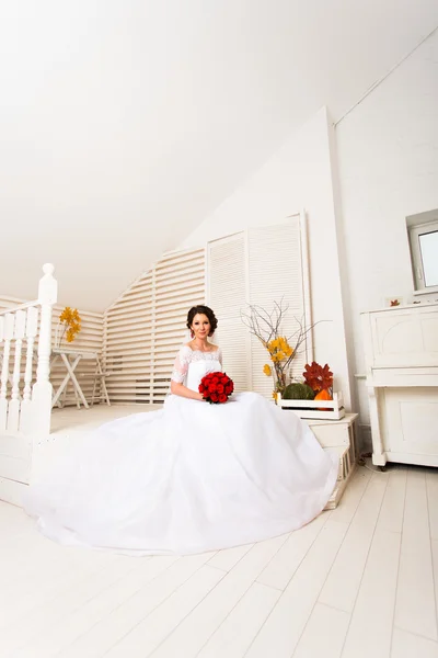Retrato da bela noiva com buquê vermelho dentro de casa — Fotografia de Stock