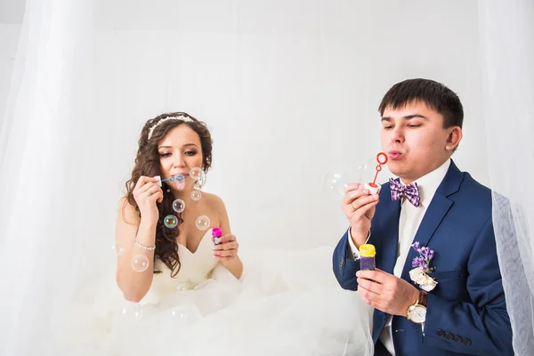 Hermosa boda pareja soplando burbujas — Foto de Stock