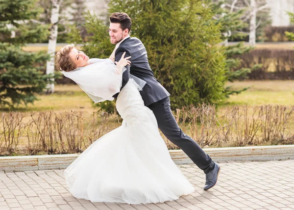 Жених держит невесту в танцевальной позе в день свадьбы — стоковое фото